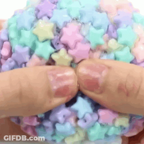Hands Holding Candy Ball With Stars GIF