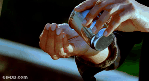Hands Holding Small Silver Object GIF