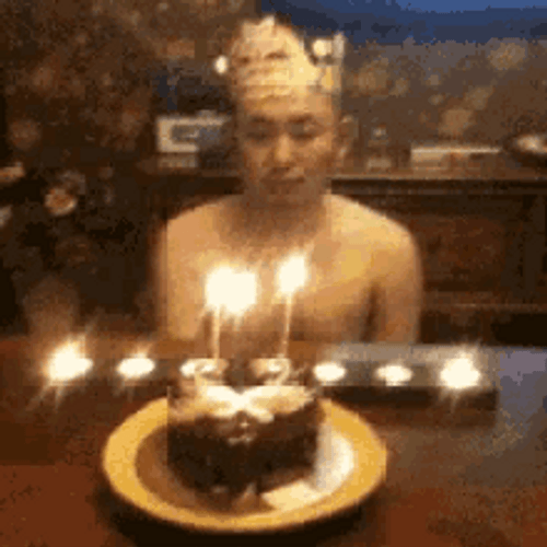 Happy Guy Blowing Rows Of Birthday Candles GIF
