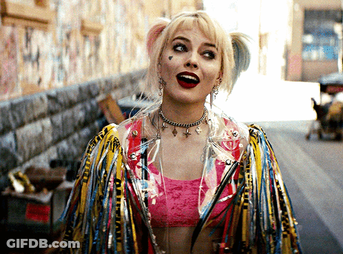 Harley Quinn Is Wearing A Pink Top And A Jacket With Feathers On It GIF