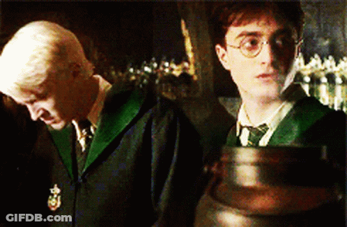 Harry Potter And Draco Malfoy Are Standing Next To Each Other In A Dark Room GIF