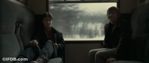 Harry Potter And Ron Weasley Are Sitting On A Train Looking Out Of A Window . GIF