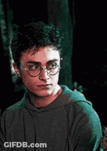 Harry Potter Is Wearing Glasses And A Green Hoodie While Looking Down . GIF
