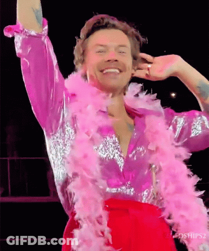 Harry Styles In Pink And Silver Outfit With Pink Boa GIF