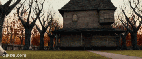 Haunted House Surrounded By Trees And Fence GIF