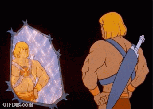 He Man Is Looking At Himself In A Mirror While Holding A Sword GIF