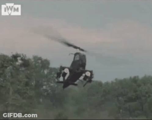Helicopter Flying Over Forest With IWM Letters GIF
