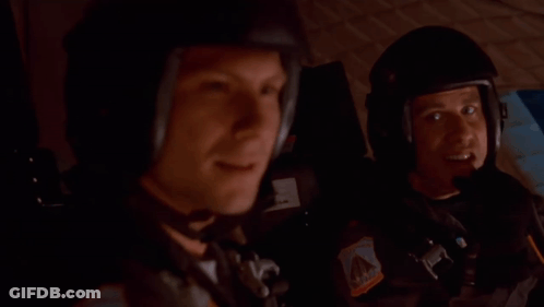 Helmeted Man Next To Man In Car GIF