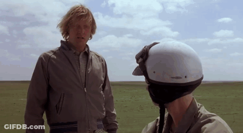 Helmeted Man Talking To Man In Field GIF