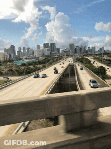 Highway With City Background And Cars Driving GIF