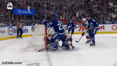 Hockey Game In Front Of Esso Banner GIF