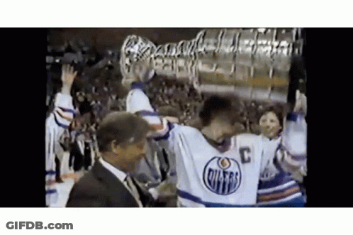 Hockey Player Holding Trophy With Man Behind GIF