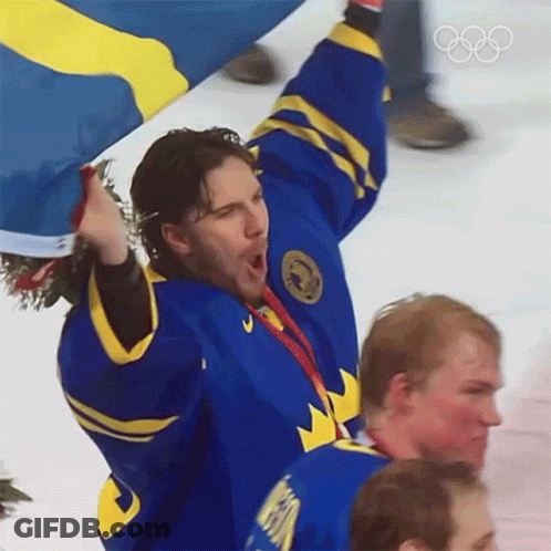 Hockey Player In Blue And Yellow Jersey Holding Flag GIF