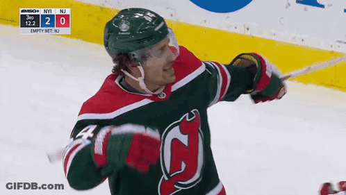 Hockey Player In Green And Red Jersey Holding Stick GIF