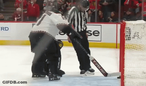 Hockey Player Kneeling On Ice With Referee GIF
