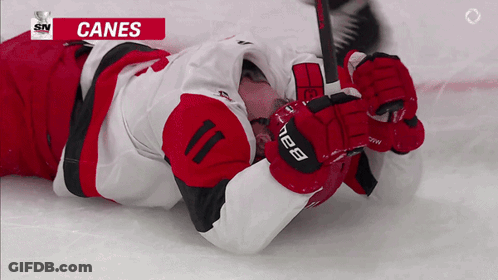 Hockey Player Laying On Ice With Canes GIF