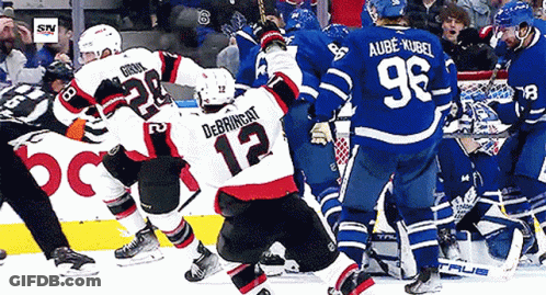 Hockey Player Number 12 Surrounded By Players GIF