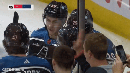 Hockey Player Number 59 Surrounded By Teammates GIF