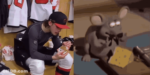 Hockey Player Sitting In Locker Room Beside Mouse Eating Cheese GIF