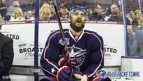 Hockey Player Sitting In Stands Holding Stick GIF