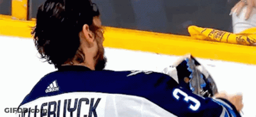 Hockey Player Sitting On Ice In Blue And White Jersey GIF