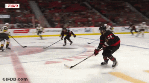 Hockey Player With Number 28 Holding Puck GIF