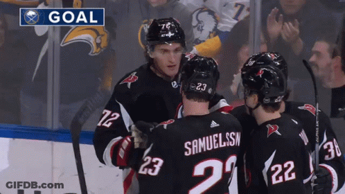 Hockey Players Celebrating Under Goal Banner GIF