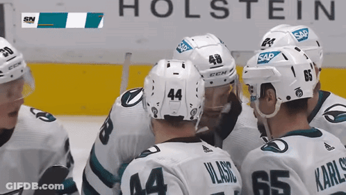 Hockey Players Huddled In Front Of Holstein Sign GIF