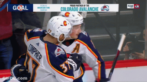 Hockey Players Hugging In Front Of Avalanche Ad GIF