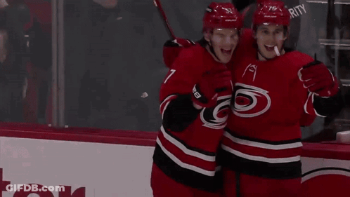 Hockey Players In Red And Black Uniforms GIF