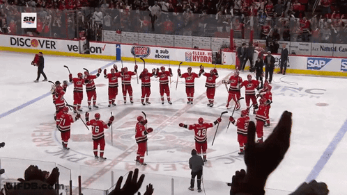 Hockey Players On The Ice In Front Of A Banner That Says Discover GIF