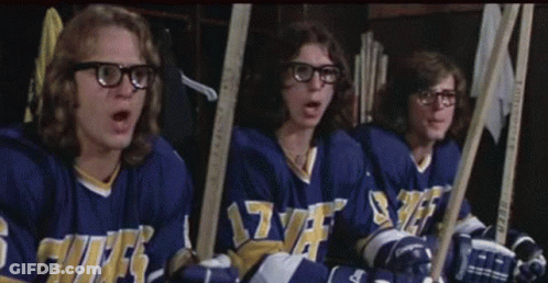 Hockey Players Sitting In Locker Room With Sticks GIF