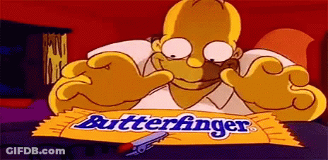 Homer Simpson Is Sitting At A Table With A Wrapper Of Butterfinger Chocolate Bar . GIF