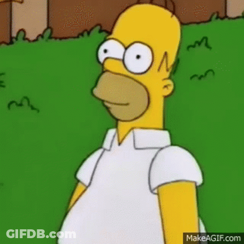 Homer Simpson Is Standing In The Grass Wearing A White Shirt And Looking At The Camera . GIF