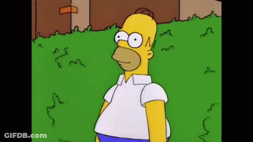 Homer Simpson Is Standing In The Grass Wearing A White Shirt GIF