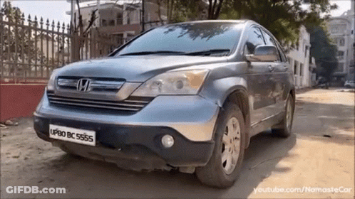 Honda CRV Parked On Dirt Road In Front Of Fence GIF