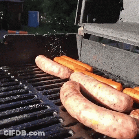 Hot Dogs Cooking On Grill With Salt Sprinkled GIF