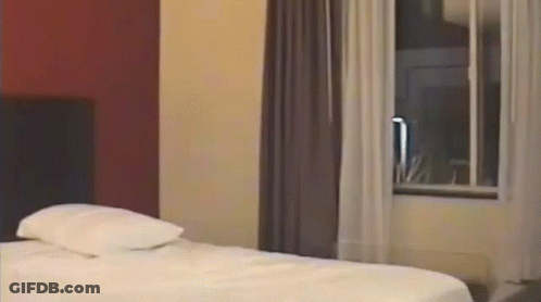 Hotel Room With Bed And Curtained Window GIF
