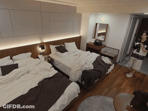 Hotel Room With Two Beds And Person In Doorway GIF