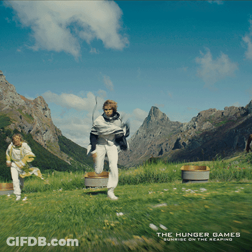 Hunger Games Poster Two People Running Through Field GIF
