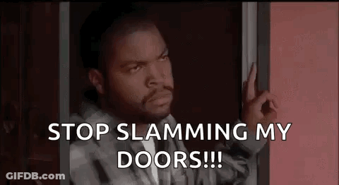 Ice Cube Is Standing In A Doorway With His Hand On The Door . GIF