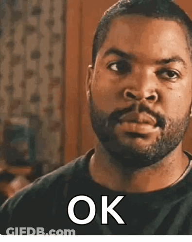 Ice Cube Is Wearing A Black Shirt And Has A Beard And The Word Ok On His Face . GIF