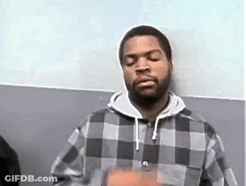 Ice Cube Is Wearing A Plaid Shirt And A Hoodie While Standing In Front Of A Wall . GIF
