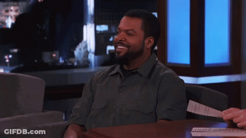 Ice Cube Smiling At Table With Paper GIF