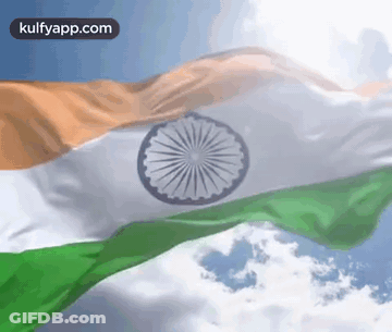 Indian Flag Waving In Wind Against Blue Sky With Clouds GIF