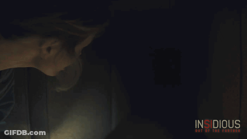Insidious Poster Woman Holding Lighter In Dark Room GIF