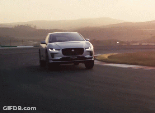 Jaguar Car Driving On Road With Mountains GIF