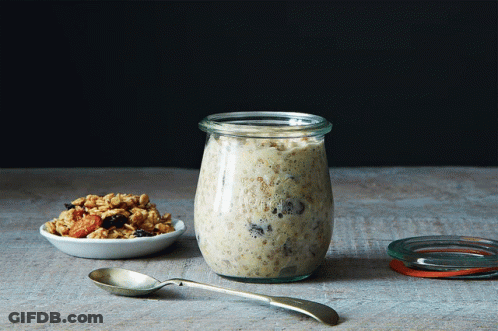 Jar Of Oatmeal Next To Bowl Of Granola And Spoon GIF