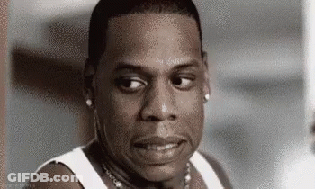 Jay Z Is Wearing A White Tank Top And A Necklace And Looking At The Camera . GIF