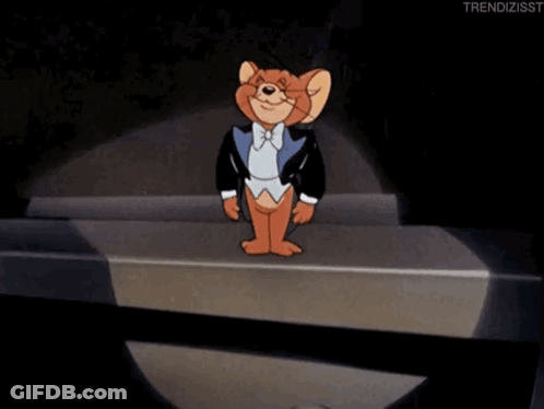 Jerry From Tom And Jerry Is Wearing A Tuxedo And Standing On A Stage GIF